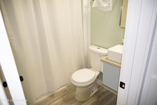 bathroom with hardwood / wood-style floors, vanity, and toilet