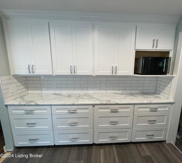 kitchen featuring tasteful backsplash, white cabinetry, light stone countertops, and dark hardwood / wood-style floors