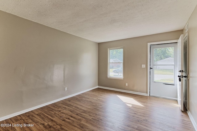 unfurnished room with a textured ceiling and hardwood / wood-style floors