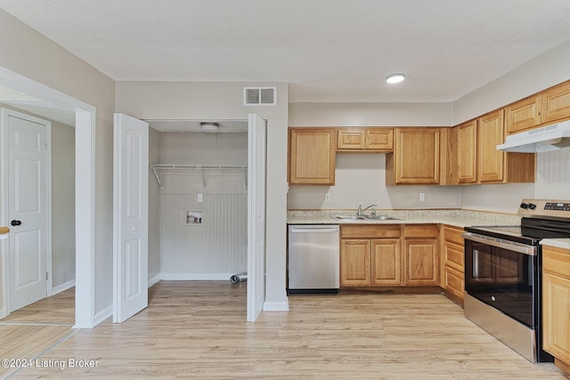 kitchen featuring a textured ceiling, light hardwood / wood-style floors, sink, and stainless steel appliances