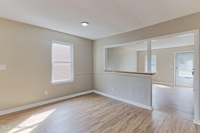 empty room featuring light hardwood / wood-style flooring and a textured ceiling