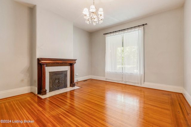 unfurnished living room with a chandelier and wood-type flooring