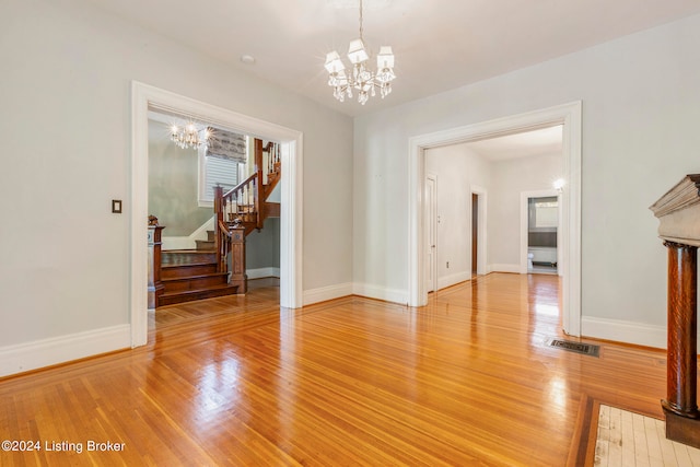 unfurnished dining area featuring hardwood / wood-style flooring and a chandelier