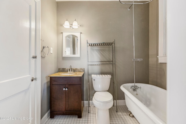 bathroom featuring tile patterned flooring, a tub, vanity, and toilet