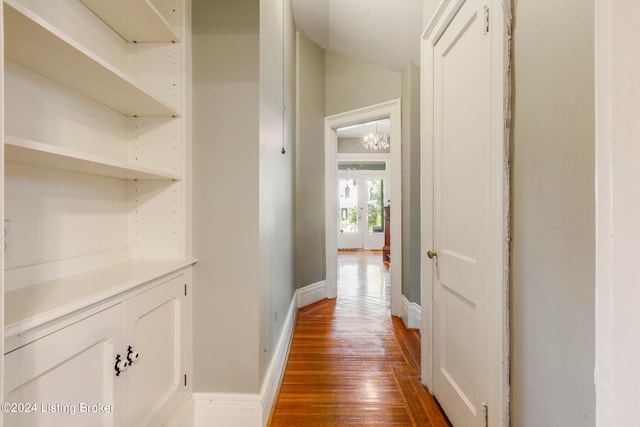 hall featuring lofted ceiling, a chandelier, and dark wood-type flooring