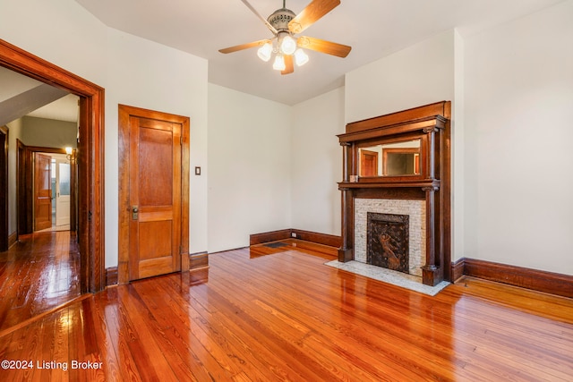 unfurnished living room with wood-type flooring and ceiling fan