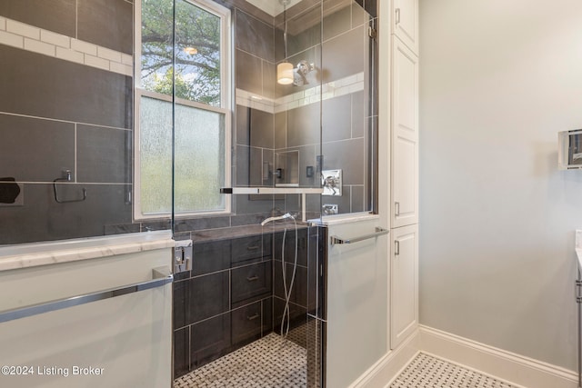 bathroom featuring vanity, tile patterned floors, a tile shower, and a wealth of natural light