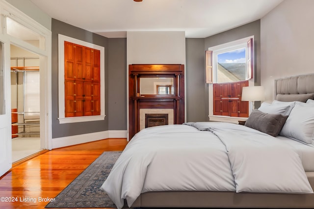 bedroom featuring a closet, light hardwood / wood-style floors, and ensuite bath