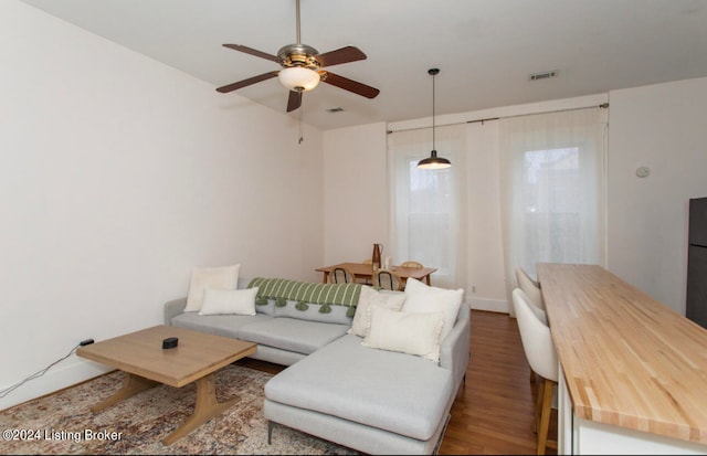 living room featuring ceiling fan and dark hardwood / wood-style floors