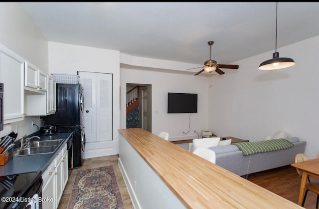 kitchen with ceiling fan, white cabinets, hanging light fixtures, and wood counters