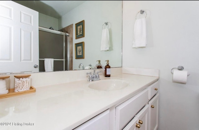 bathroom featuring vanity and a shower with door