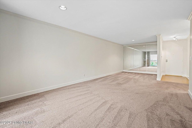 empty room featuring crown molding and carpet