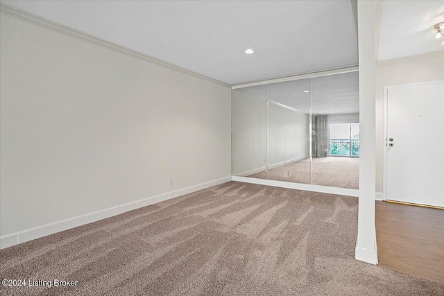 unfurnished room featuring ornamental molding and carpet flooring