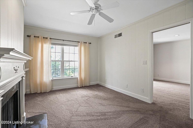 unfurnished living room with ceiling fan, ornamental molding, and carpet