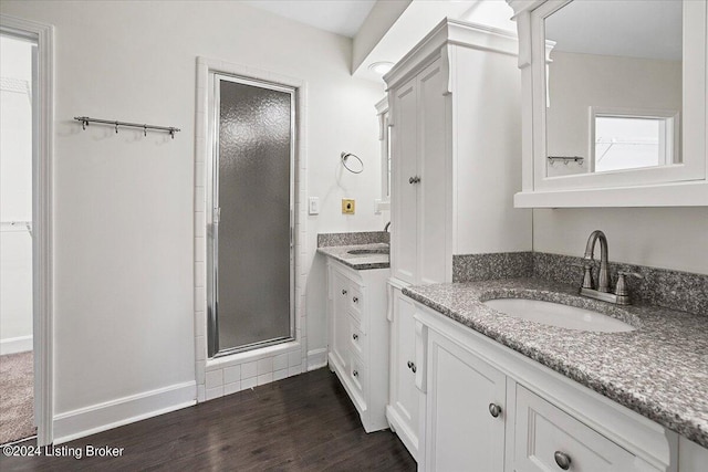 bathroom featuring wood-type flooring, vanity, and a shower with door