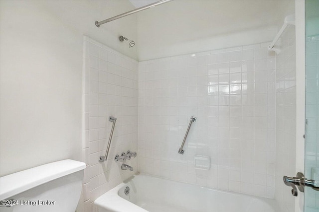 bathroom featuring tiled shower / bath combo and toilet