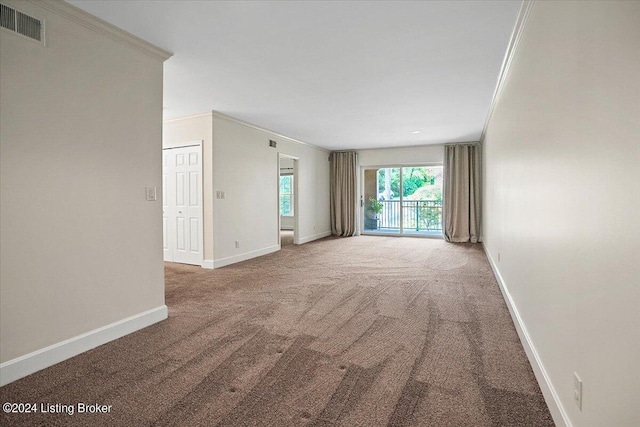 spare room featuring ornamental molding and carpet flooring