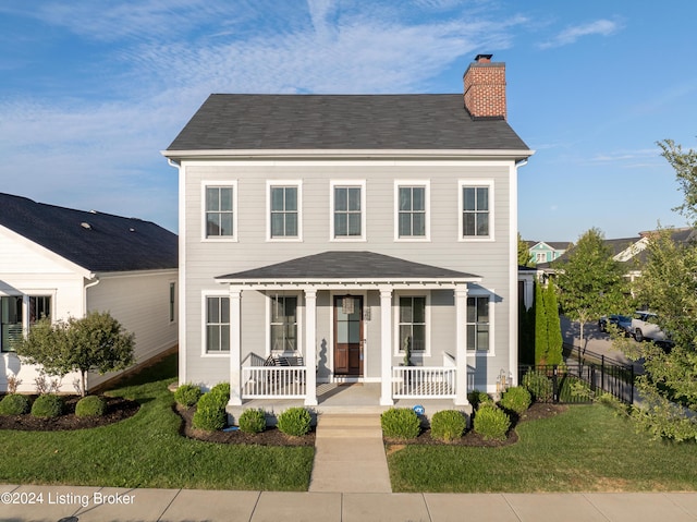 view of front facade with a front yard and covered porch