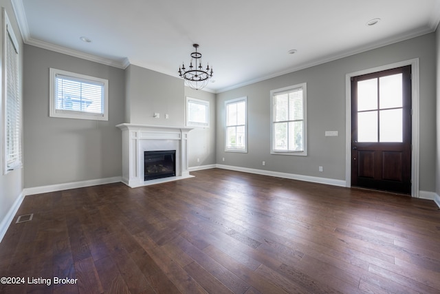 unfurnished living room featuring ornamental molding, an inviting chandelier, and dark wood-type flooring