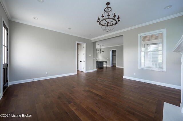 unfurnished living room featuring ornamental molding, dark wood-type flooring, and a chandelier