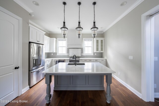 kitchen with dark wood-type flooring, stainless steel refrigerator with ice dispenser, white cabinetry, hanging light fixtures, and a center island with sink