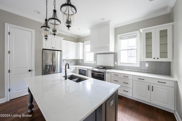 kitchen with dark hardwood / wood-style floors, a kitchen island with sink, sink, white cabinets, and stainless steel appliances