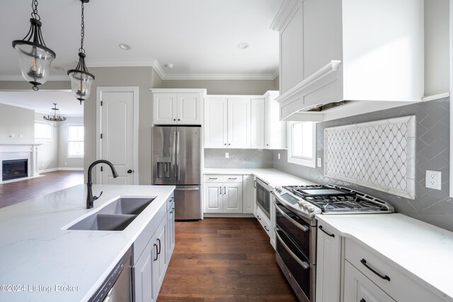 kitchen with appliances with stainless steel finishes, hanging light fixtures, white cabinets, dark hardwood / wood-style flooring, and sink