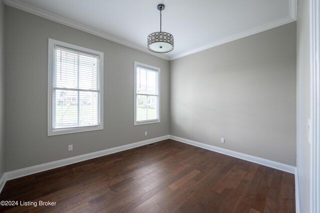 empty room featuring ornamental molding and dark hardwood / wood-style flooring