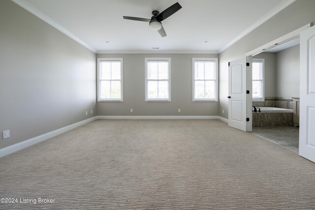 spare room with light carpet, ceiling fan, plenty of natural light, and crown molding