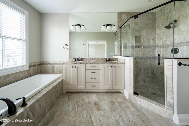 bathroom featuring plenty of natural light, vanity, and separate shower and tub