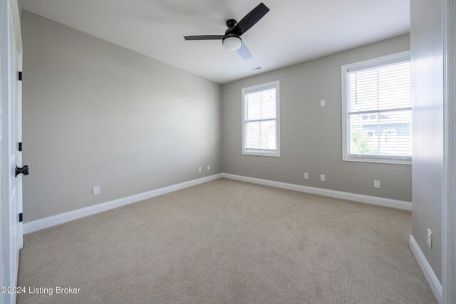 empty room with ceiling fan and light colored carpet