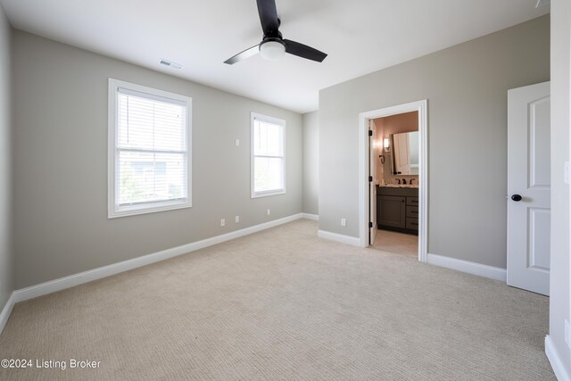 unfurnished bedroom with ceiling fan, connected bathroom, and light carpet