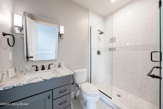 bathroom with walk in shower, vanity, and toilet