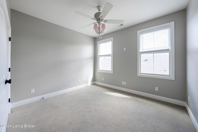 carpeted spare room with ceiling fan