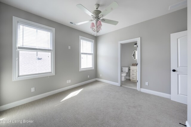 unfurnished bedroom with ensuite bath, ceiling fan, and light colored carpet