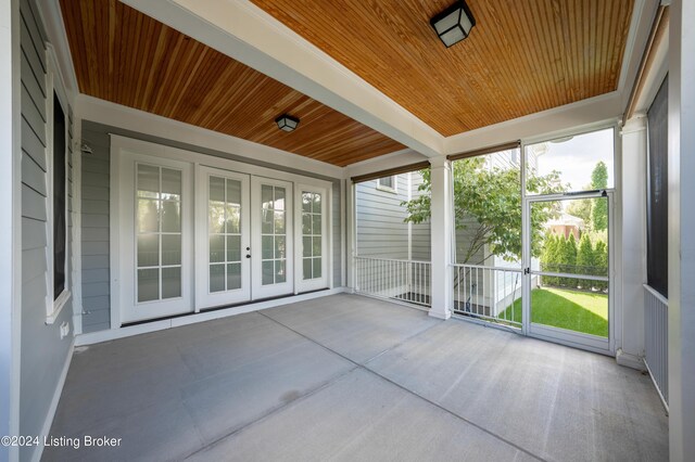 unfurnished sunroom with wood ceiling and french doors