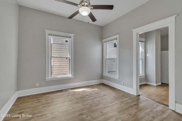 unfurnished bedroom featuring a closet, light wood-type flooring, multiple windows, and ceiling fan