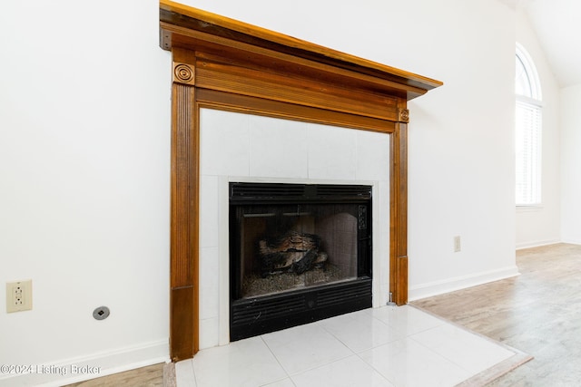 room details featuring wood-type flooring and a tiled fireplace