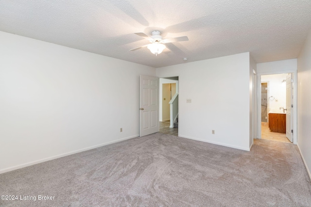 carpeted spare room with a textured ceiling and ceiling fan