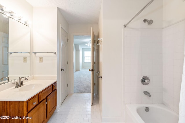 bathroom featuring a textured ceiling, shower / tub combo, tile patterned flooring, and vanity