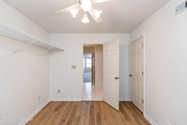 interior space featuring light hardwood / wood-style flooring, a textured ceiling, and ceiling fan