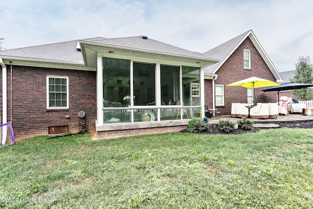 back of house featuring a lawn and a sunroom