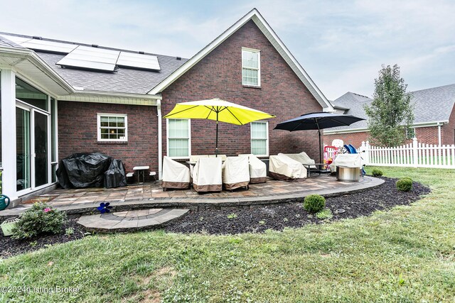 back of property featuring a lawn and a patio