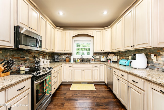 kitchen featuring light stone countertops, stainless steel appliances, dark wood-type flooring, and sink