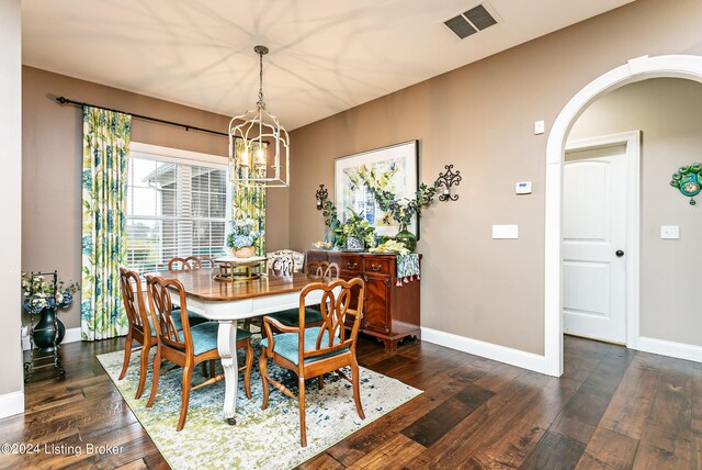 dining area featuring dark wood-type flooring and a notable chandelier