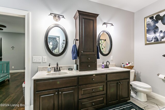 bathroom with wood-type flooring, vanity, and toilet