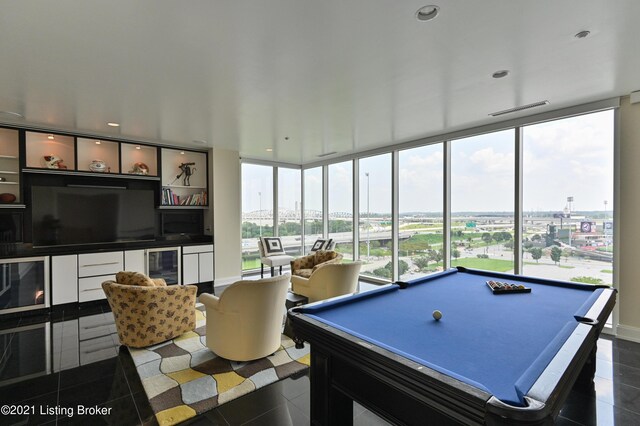 rec room with a healthy amount of sunlight, dark tile patterned flooring, floor to ceiling windows, visible vents, and pool table