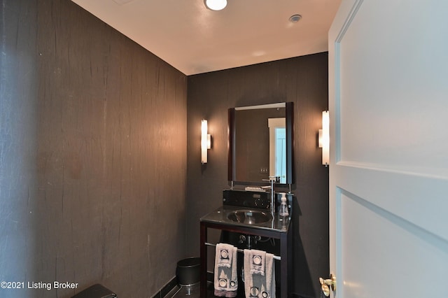bathroom featuring wooden walls and vanity