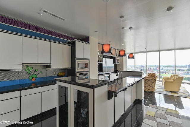 kitchen with backsplash, appliances with stainless steel finishes, dark countertops, visible vents, and white cabinets