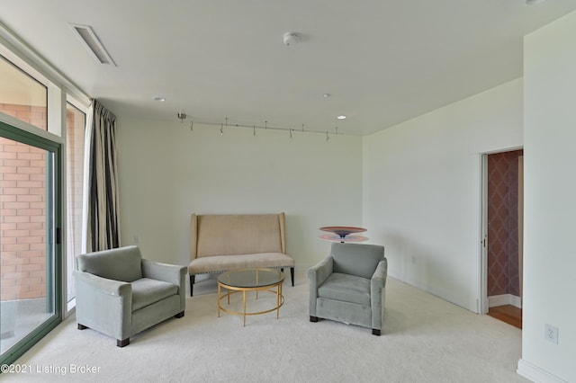 living area featuring baseboards, visible vents, and carpet